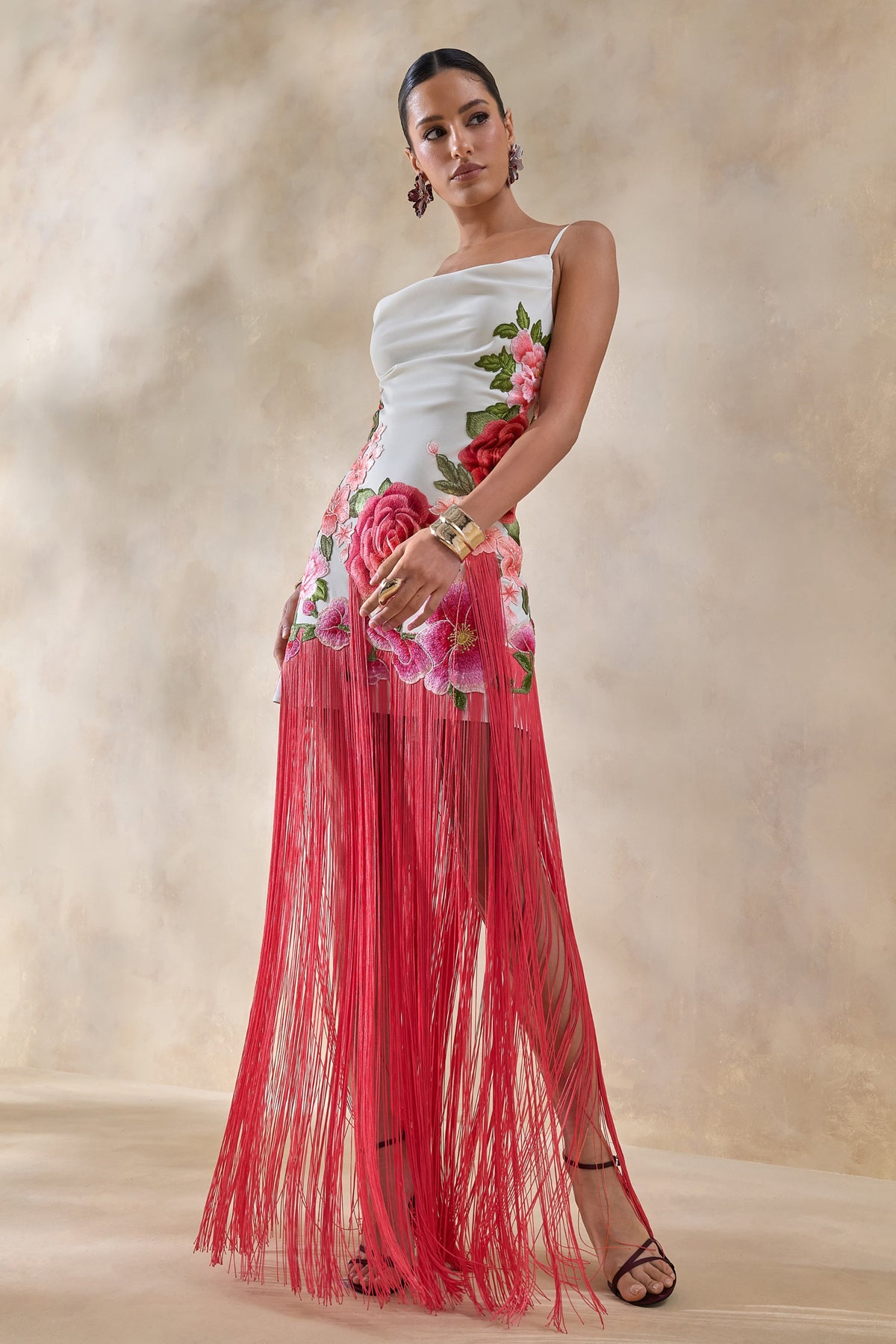 Bejewelled | Vestido largo blanco con flores rosas, escote drapeado tipo cowl y bajo con flecos