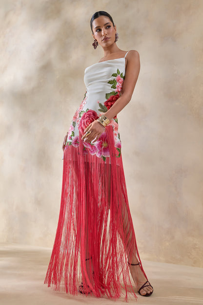 Bejewelled | Vestido largo blanco con flores rosas, escote drapeado tipo cowl y bajo con flecos