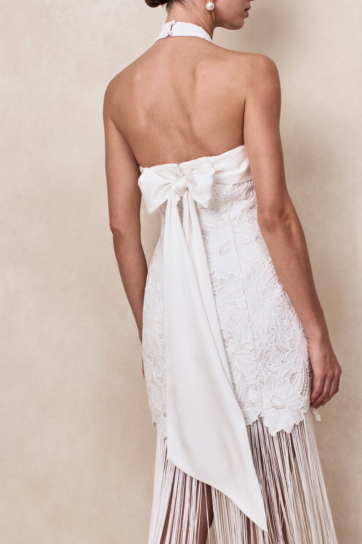 Skylar | Vestido Largo de encaje blanco con escote halter, espalda descubierta, corte sirena y detalle de lazo