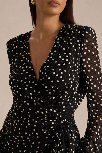 Mela | Vestido corto negro y blanco de lunares con escote pronunciado, mangas campana y Fajín