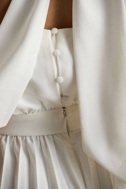 Paradise | Mono blanco con detalle de lazada en el cuello y manga tipo capa